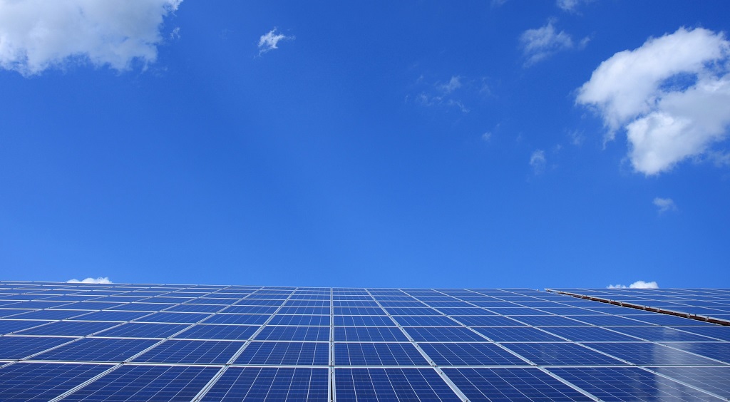 Blue solar panels under sunny sky